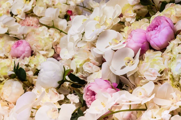 Fundo floral. Muitas flores artificiais em colorido — Fotografia de Stock