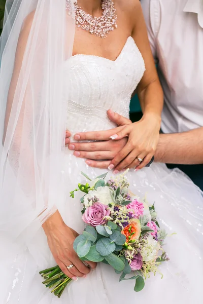 Lo sposo abbraccia la sposa con bel mazzo nuziale — Foto Stock