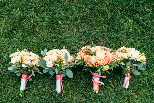 Bouquets de casamento de noiva e damas de honra na grama com lugar fo — Fotografia de Stock