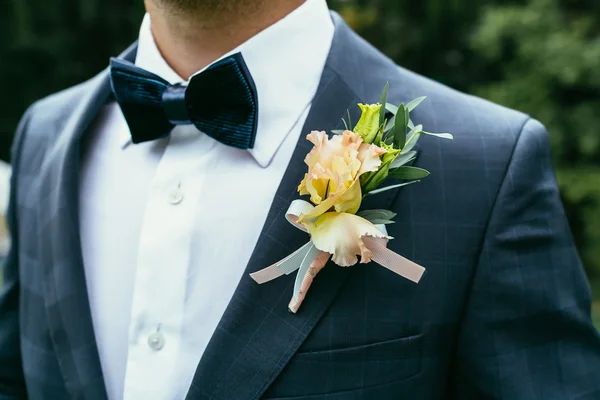 Wedding boutonniere on chequered suit of groom with bow-tie — Stock Photo, Image