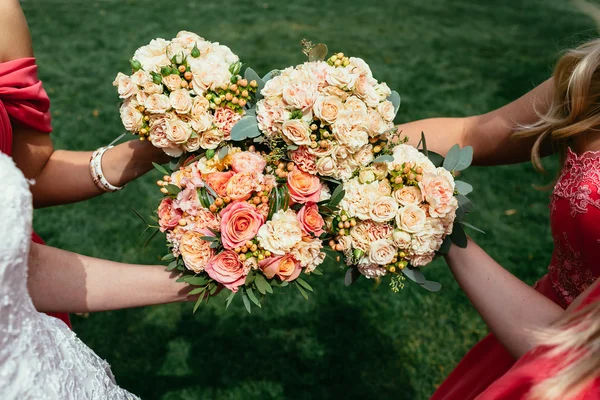 Noiva em vestido de noiva e damas de honra vestir vermelho segurando Wedd — Fotografia de Stock