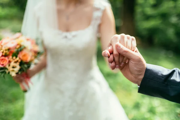 Brudgummen har en brudar hand på bröllop — Stockfoto