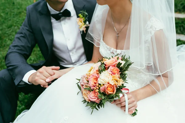 Novio sosteniendo una mano de novia con ramo de bodas en el día de la boda —  Fotos de Stock