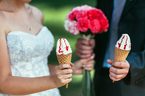 Gelin ve damat dondurma ve düğün buketi içinde tutarak onların ha — Stok fotoğraf