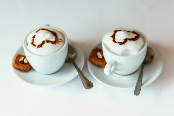 Kapuçino karşı kurabiyeyle iki fincan gurme kahve evi — Stok fotoğraf