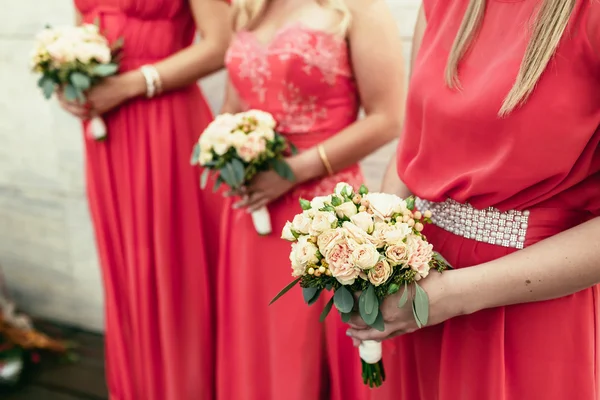 Brudtärna samma klädd med Buketter av rosor och andra flo — Stockfoto