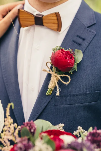 Noivos com laço de madeira e vermelho rosa boutonniere no casamento d — Fotografia de Stock