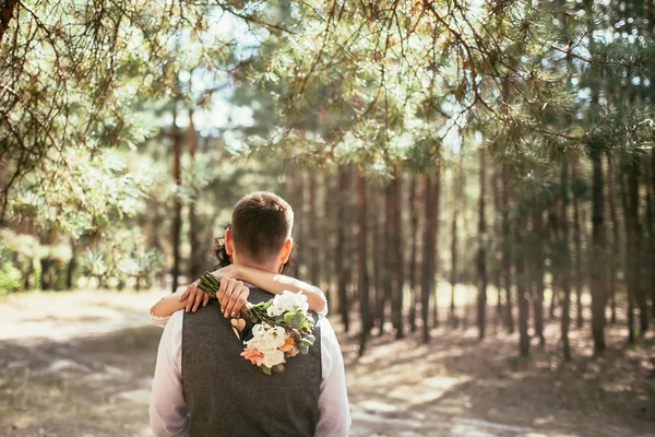 Bride hug groom with bouquet on wedding ceremony in forest — Stock Photo, Image