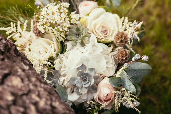 Rosen, Sukkulenten und andere Blumen im Hochzeitsstrauß auf Grün — Stockfoto