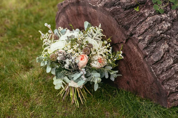 Rustic wedding bouquet with roses and other flowers on green gra — Stock Photo, Image