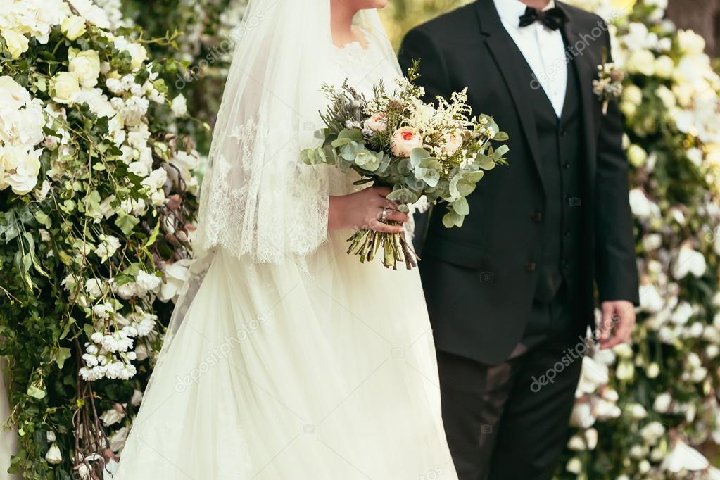 groom in black suit and bride in white wedding dress with rustic