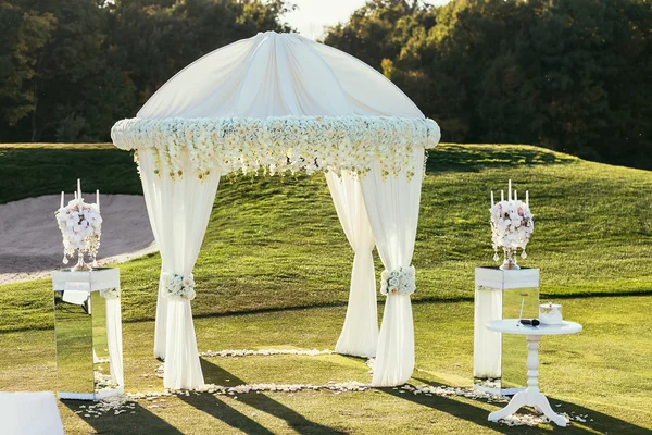 Arco de boda blanco con flores y decoración de velas en soleado — Foto de Stock