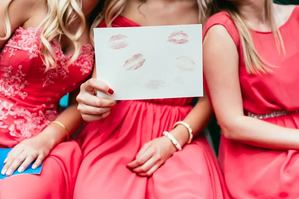 Девушки держат бумагу с поцелуями красной помады — стоковое фото