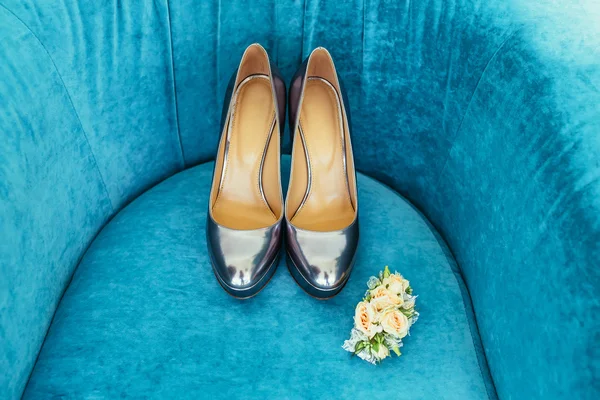 Chaussures de mariée argentées avec boutonnière de mariage sur canapé bleu — Photo