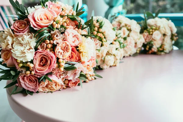 結婚式の花嫁とブライドメイド ceremo する前にテーブルの上の花束 — ストック写真