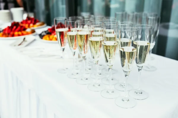a row of glasses filled with champagne are lined up ready to be