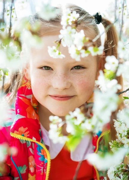 Menina bonita em um jardim florido — Fotografia de Stock