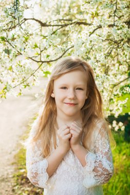 Güneşli bahar bahçe beyaz bir elbise, küçük kız