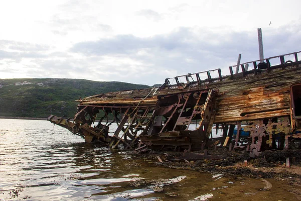 Gemi mezarlığı. Rusya 'da terk edilmiş batık bir balıkçı teknesi, Kola Yarımadası, Barents Denizi, Teriberka.