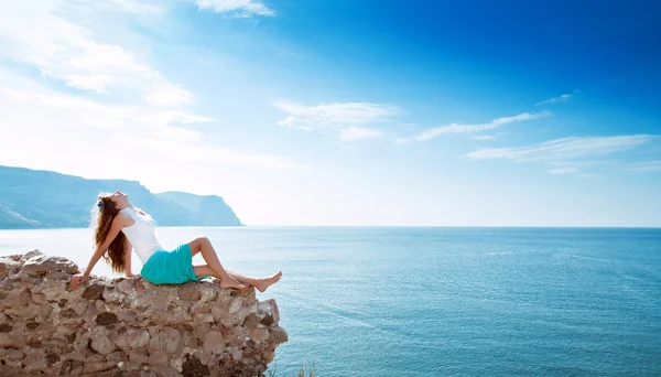 Ung vacker flicka i bergen på en bakgrund av havet — Stockfoto