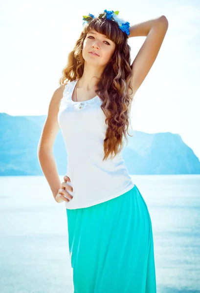 Young beautiful girl in mountains on a background of the sea — Stock Photo, Image