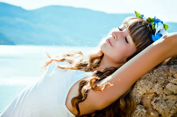 Young beautiful girl in mountains on a background of the sea — Stock Photo, Image