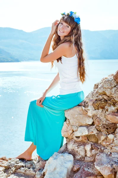 Young beautiful girl in mountains on a background of the sea — Stock Photo, Image