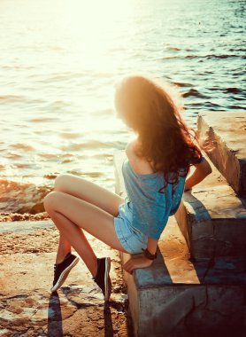 Deniz ve güneş bir arka plan üzerinde genç güzel kız