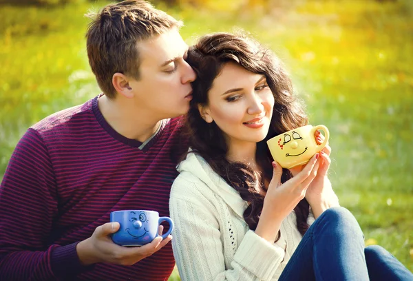 Pareja joven relajarse en la naturaleza y beber té — Foto de Stock