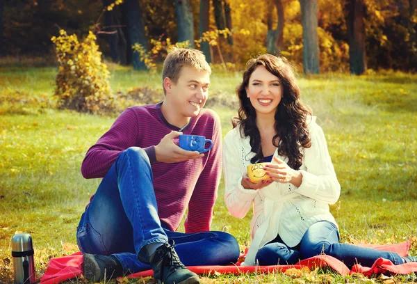 Pareja joven relajarse en la naturaleza y beber té — Foto de Stock