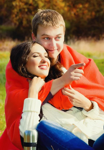 Jovem casal sentado abraçando a natureza — Fotografia de Stock