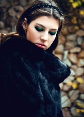 Taş bir duvara yakın poz şık genç kadın