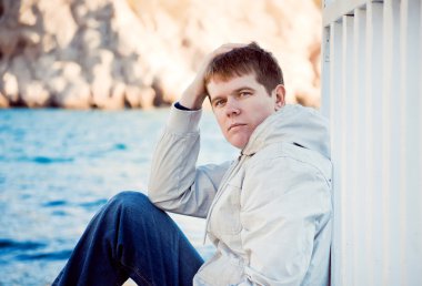 Deniz arka plan üzerinde genç yakışıklı bir adam portresi