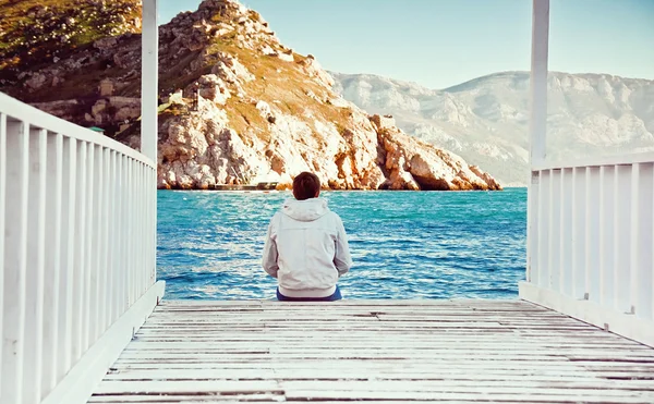 Jovem solitário sentado na doca — Fotografia de Stock