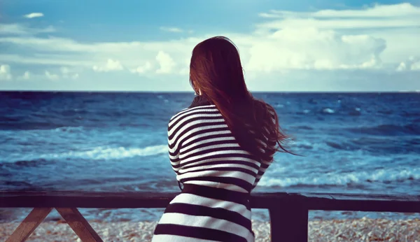 Bella ragazza guarda il mare — Foto Stock