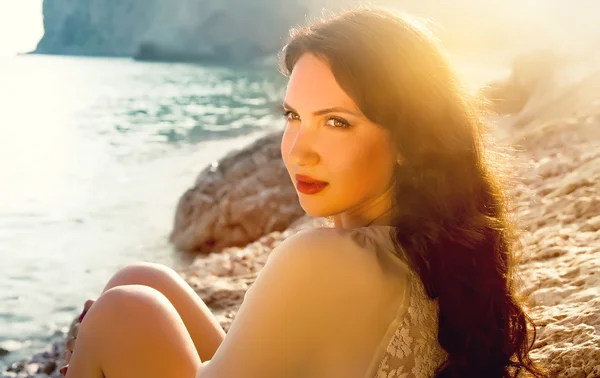 Красивая молодая девушка, сидящая на пляже одна — стоковое фото