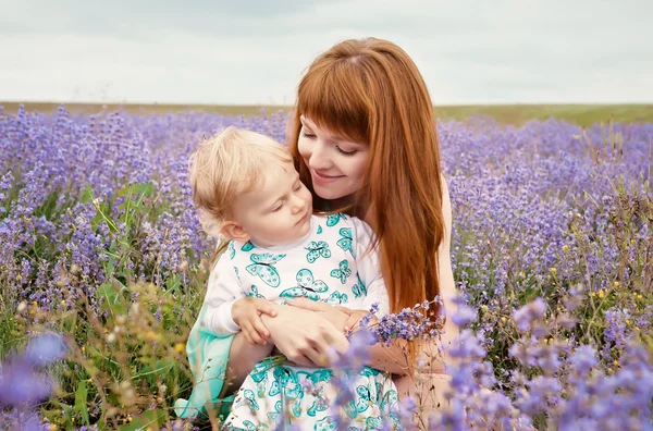 Portret van een mooie jonge moeder en kind in de natuur — Stockfoto