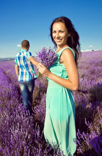 Young attractive couple in a field in summer — Stock Photo, Image