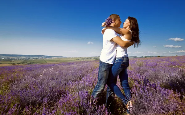 Jovem casal atraente em um campo no verão — Fotografia de Stock