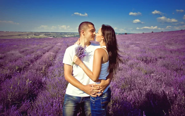 Jovem casal atraente em um campo no verão — Fotografia de Stock