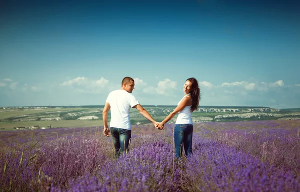 Unga attraktiva paret i ett fält i sommar — Stockfoto