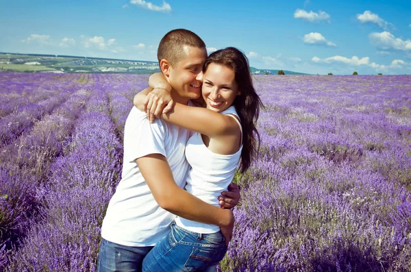 Young attractive couple in a field in summer — Stock Photo, Image