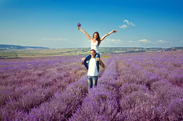 Young attractive couple in a field in summer — Stock Photo, Image