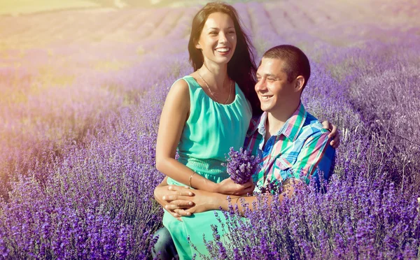 Unga attraktiva paret i ett fält i sommar — Stockfoto