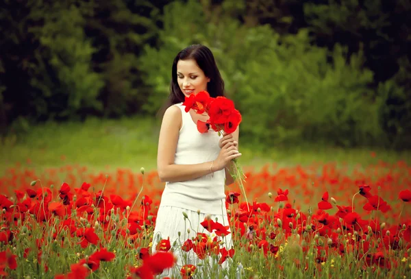 Wanita cantik di lapangan dengan bunga — Stok Foto
