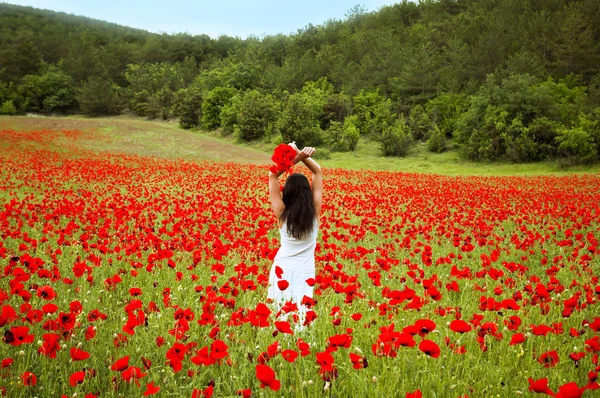 Ritratto di una bella donna in un campo con fiori — Foto Stock