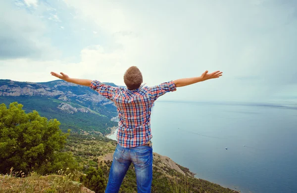 Guy on top of a mountain with arms outstretched — Stock Photo, Image