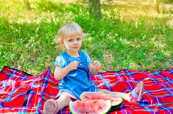 Karpuz ile parkta oturan küçük şirin kız — Stok fotoğraf