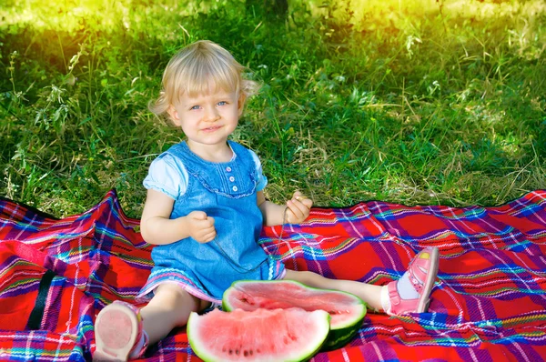 Little cute girl sitting in the park with watermelon — Stock Photo, Image