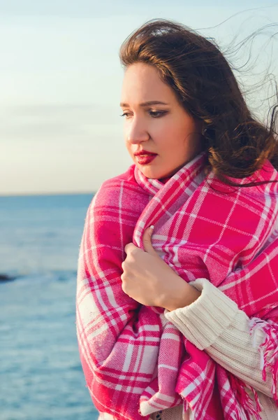 Attraente ragazza in piedi vicino al mare avvolto in una coperta — Foto Stock